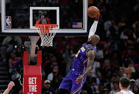 Los Angeles Lakers' LeBron James goes up for a dunk against the Houston Rockets during the first half of an NBA basketball game in Houston. 