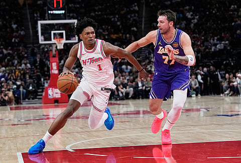 Houston Rockets' Amen Thompson (1) drives toward the basket as Los Angeles Lakers' Luka Doncic (77) defends during the first half of an NBA basketball game in Houston. 