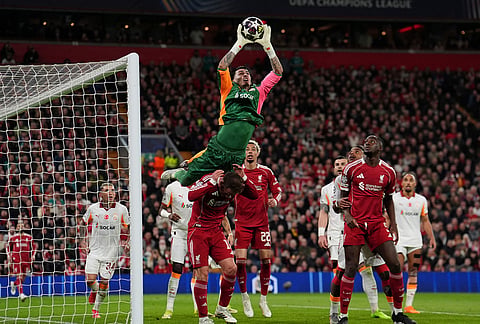 Galatasaray's goalkeeper Ugurcan Cakir reaches for a high ball over Liverpool's Alexis Mac Allister during the second leg of the Champions League round of 16 soccer match between Liverpool and Galatasaray, in Liverpool, England. 