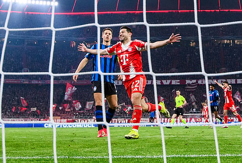 Bayern Munich's Raphaël Guerreiro celebrates after Lennart Karl scores to make it 3-0 against Atalanta Bergamo, in Munich, Germany.