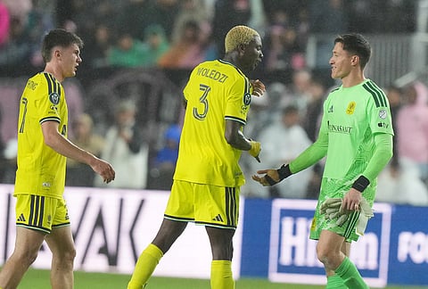 Nashville defender Maxwell Woledzi (3) and goalkeeper Brian Schwake celebrate after defeating Inter Miami in a CONCACAF Champions Cup Round of 16 soccer match, in Fort Lauderdale, Florida.