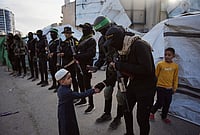 Hamas Dissolves Gaza Government: Why Is It Refusing To Disarm? | Photo: AP/Abdel Kareem Hana : Palestinian militants from Hamas and Islamic Jihad greet people who gather for to Eid al-Fitr prayers in Gaza City, Friday, March 20, 2026.