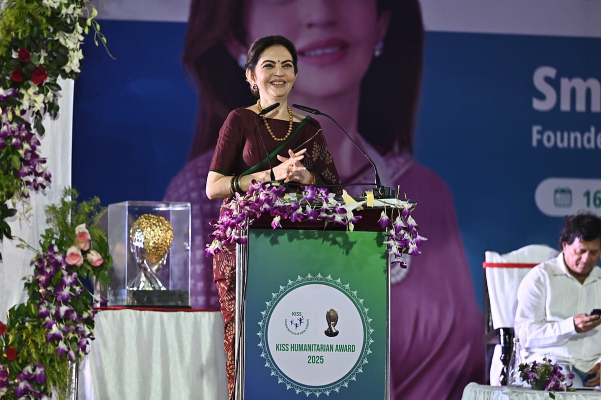 Nita Ambani smiling at the podium of the KISS Humanitarian Award
