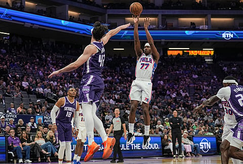Philadelphia 76ers guard Vj Edgecombe (77) shoots a three-point basket over Sacramento Kings center Maxime Raynaud (42) during the first half of an NBA basketball game in Sacramento, California.
