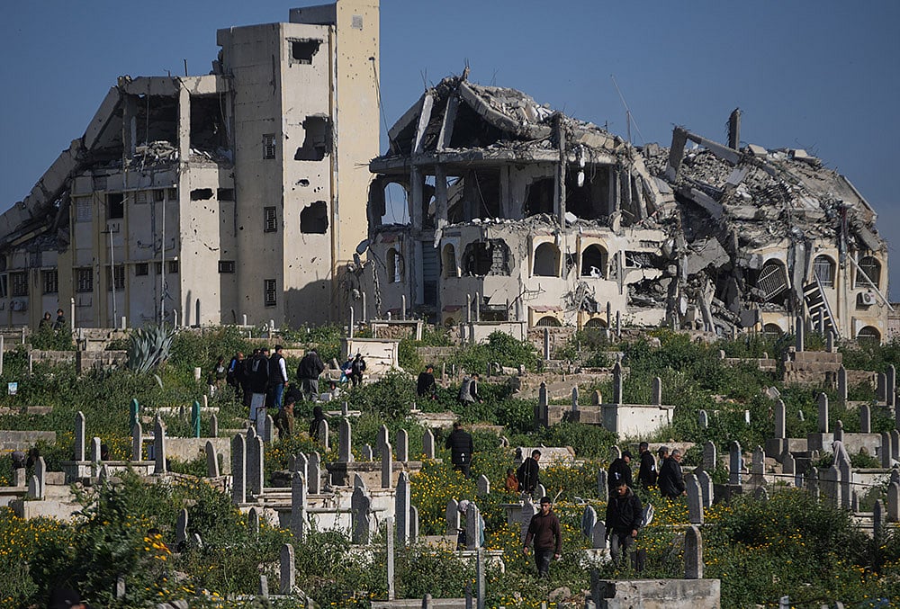 Palestinians visit the graves of their relatives who were killed in the Israel-Hamas war on the first day of the Muslim holiday of Eid al-Fitr in Gaza City, Friday, March 20, 2026.  - | Photo: AP/Abdel Kareem Hana