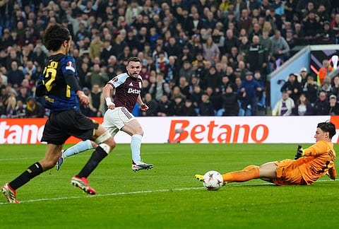 Aston Villa's John McGinn, center, scores the opening goal during the Europa League round of sixteen second leg soccer match between Aston Villa and LOSC Lille in Birmingham, England.