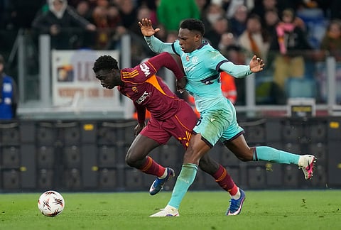 Roma's Robinio Vaz, left, and Bologna's Jhon Lucumi fight for the ball during the Europa League round of 16 second leg soccer match between Roma and Bologna in Rome, Italy.