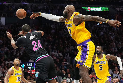 Miami Heat guard Norman Powell (24) passes the ball as Los Angeles Lakers forward LeBron James (23) defends during the second half of an NBA basketball game, in Miami.