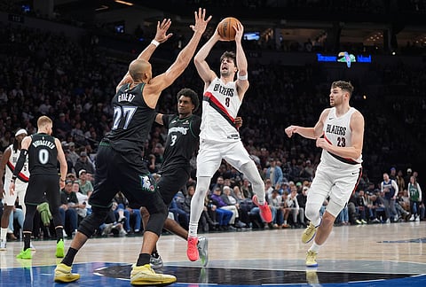 Portland Trail Blazers forward Deni Avdija (8) is fouled by Minnesota Timberwolves forward Jaden McDaniels (3) during the second half of an NBA basketball game, in Minneapolis. 