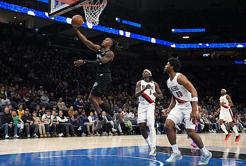 Minnesota Timberwolves guard Ayo Dosunmu (13) goes up to shoot during the first half of an NBA basketball game against the Portland Trail Blazers in Minneapolis. 