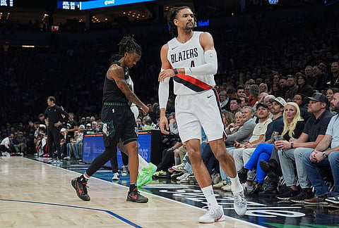 Minnesota Timberwolves guard Bones Hyland, center left, reacts nearto Portland Trail Blazers guard Matisse Thybulle, center right, after missing a shot during the first half of an NBA basketball game in Minneapolis. 