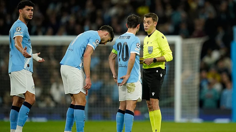 Referee Clement Turpin talks with Manchester City's Bernardo Silva before checking the VAR for a red card during the Champions League round of 16 second leg soccer match between Manchester City and Real Madrid in Manchester, Tuesday, March 17, 2026. - | Photo: AP/Dave Thompson