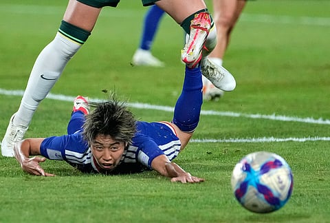 Japan's Riko Ueki hits the floor after a challenge by Australia's Winonah Heatley during the Women's Asian Cup soccer final between Japan and Australia in Sydney.