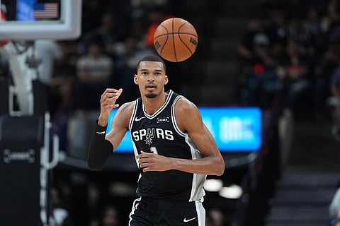 San Antonio Spurs forward Victor Wembanyama (1) reaches for a loose ball during the first half of an NBA basketball game against the Indiana Pacers in San Antonio.