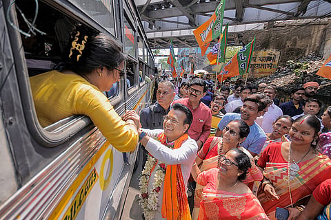 BJP candidate from Shibpur Assembly constituency Rudranil Ghosh interacts with a woman during a door-to-door campaign, in Howrah.