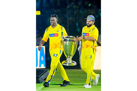 Former cricketers Suresh Raina, right, and Dwayne Bravo carry a trophy during the Chennai Super Kings’ ROAR 2026, pre-season fan event, at M. A. Chidambaram Stadium in Chennai.