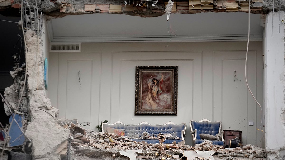 Photo: AP Photo/Vahid Salemi : Rubble covers the furniture of a destroyed living room in a residential building hit in an earlier U.S.-Israeli strike in Tehran, Iran, Monday, March 23, 2026. 
