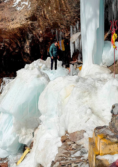 A man stands on the frozen waterfall, in Niti Valley area, Chamoli.