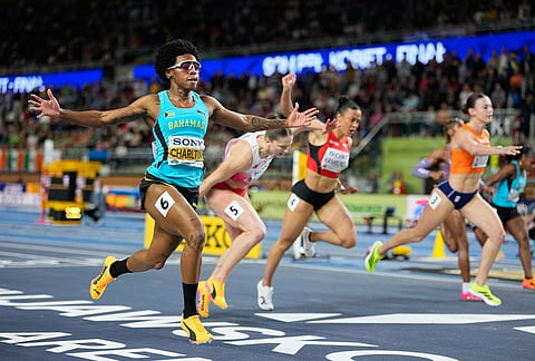 Devynne Charlton, of Bahamas, left, crosses the finish line to win the gold medal in the women's 60 meters hurdles final at the World Athletics Indoor Championships in Torun, Poland.