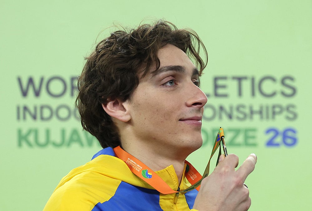 | Photo: AP/Beata Zawrzel : Armand Duplantis, of Sweden, poses on the podium after winning the gold medal in the men's pole vault at the World Athletics Indoor Championships in Torun, Poland.
