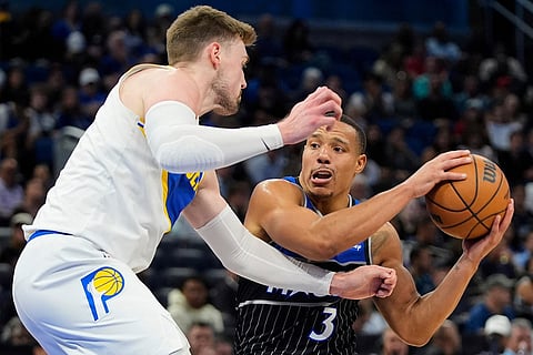 Orlando Magic guard Desmond Bane (3) looks to pass the ball against Indiana Pacers center Micah Potter, left, during the first half of an NBA basketball game in Orlando, Fla.