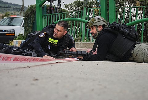 Israeli security forces take cover as air raid sirens sound, warning of rockets launched from Lebanon toward Israel, in Kiryat Shmona, northern Israel.
