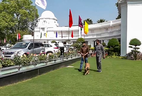 Security officials with a sniffer dog at the premises of the Delhi Legislative Assembly after it received a bomb threat via an email, in New Delhi.