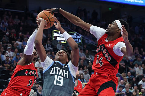 Utah Jazz guard Ace Bailey (19) has his shot blocked by Toronto Raptors guard Ja'kobe Walter (14) during the first half of an NBA basketball game in Salt Lake City.