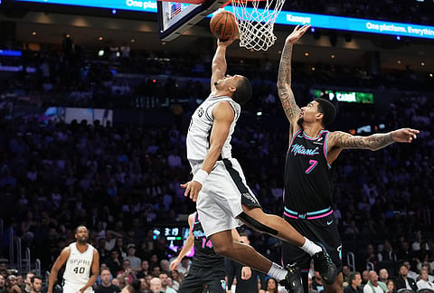 San Antonio Spurs forward Keldon Johnson, left, shoots over Miami Heat center Kel'el Ware (7) during the first half of an NBA basketball game, in Miami.