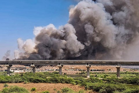 Dark smoke billows out after a fire broke out on Tuesday at the Khajod waste disposal site, in Surat.