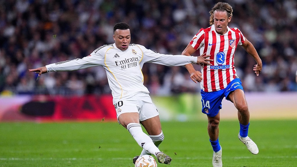 Real Madrid's Kylian Mbappe, left, and Atletico Madrid's Marcos Llorente challenge for the ball during their La Liga match in Madrid, Spain. - AP