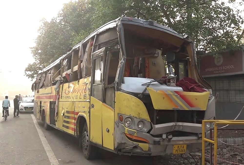 | Photo: PTI : Damaged remains of a sleeper bus after it overturned near Hanuman Mandir, in Karol Bagh area, New Delhi. Two passengers were killed and 23 others injured in the incident. 