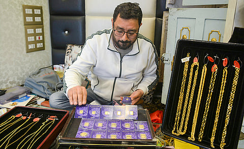 A goldsmith arranges gold biscuits at a jewellery shop, in Srinagar, Tuesday, March 24, 2026. Gold prices declined Rs 2,260 to Rs 1.37 lakh per 10 grams in futures trade on Tuesday, marking their decline for the fifth straight session amid uncertainty over geopolitical developments in West Asia. 