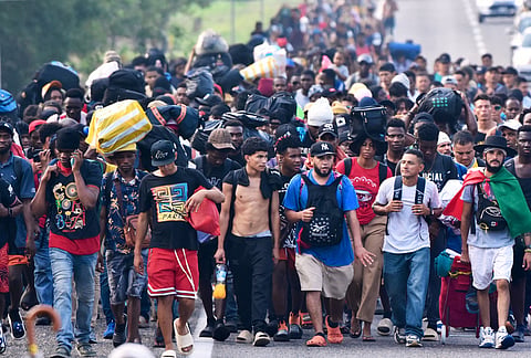 Migrants walk on the highway through the municipality of Huehuetan, Chiapas state, Mexico after leaving Tapachula the previous night. 