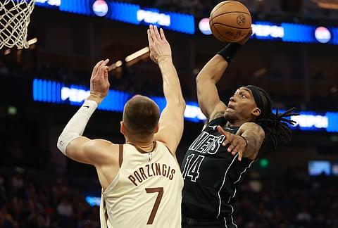 Brooklyn Nets guard Terance Mann (14) shoots against Golden State Warriors center Kristaps Porzingis (7) during the first half of an NBA basketball game in San Francisco.