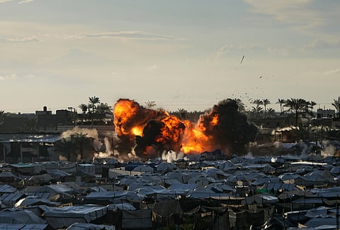 Smoke and flames rise following an Israeli military strike on a target next to a tent camp in Deir al-Balah, central Gaza Strip.