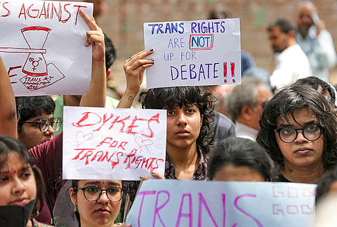 Supporters of the LGBTQIA+ community hold placards during a protest against the passage of the Transgender Persons (Protection of Rights) Amendment Bill, 2026, at Jantar Mantar in New Delhi.