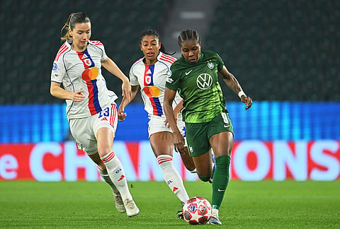 Wolfburg's Lineth Beerensteyn, right, dribbles past Lyon's Damaris Egurrola during their Champions League quarter-finals, first leg soccer match in Wolfsburg, Germany.
