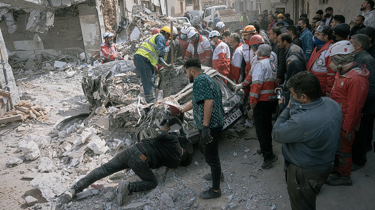 First responders inspect a destroyed car at the site of a residential building hit in an overnight strike during the U.S.-Israeli military campaign in Tabriz, East Azerbaijan Province, northwestern Iran, Tuesday, March 24, 2026 - AP Photo/ Mati Hashemi