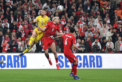 Romania's Radu Dragusin, top left, vies for a high ball with Turkey's Baris Alper Yilmaz during the 2026 World Cup playoff semifinal soccer match between Turkey and Romania, in Istanbul, Turkey.