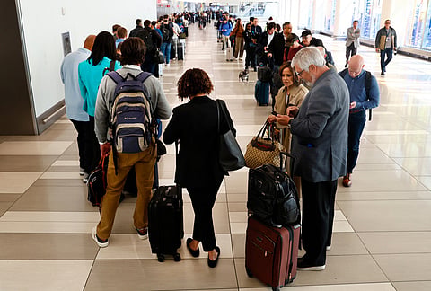 Passengers stand in the TSA pre-check line at LaGuardia Airport in New York. 
