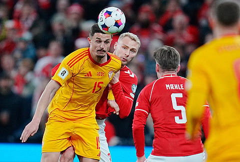 North Macedonia's Elmin Rastoder, left, and Denmark's Victor Nelsson in action during the World Cup playoff semifinal soccer match between Denmark and North Macedonia in Copenhagen.
