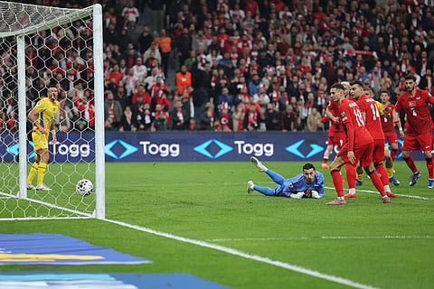 Turkey's goalkeeper Ugurcan Cakir, bottom, looks as the ball hits the pole of the goal during the 2026 World Cup playoff semifinal soccer match between Turkey and Romania, in Istanbul, Turkey.
