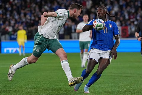 Northern Ireland's Ruairi McConville clears the ball before Italy's Moise Kean can score during the World Cup qualifying play-off soccer match between Italy and Northern Ireland, in Bergamo, Italy.