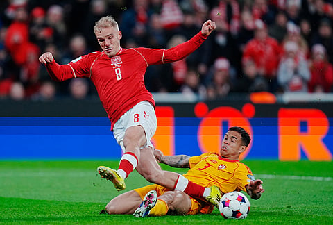 North Macedonia's Sebastian Herrera tackles Denmark's Gustav Isaksen during the World Cup playoff semifinal soccer match between Denmark and North Macedonia in Copenhagen.