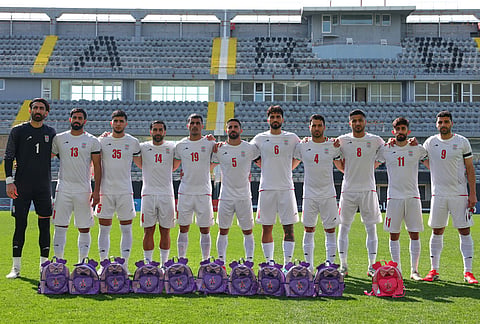 Iran's players pose for a photographer next to school bags, symbolizing children allegedly killed in a U.S. strike on a school in Minab, before a friendly soccer match between Iran and Nigeria, in Antalya, southern Turkey.