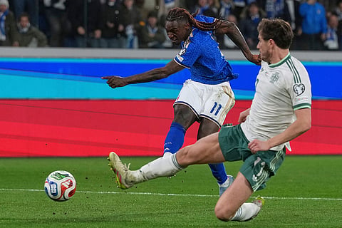 Italy's Moise Kean shoots on goal as Northern Ireland's Paddy McNair slides to stop the shot during the World Cup qualifying play-off soccer match between Italy and Northern Ireland, in Bergamo, Italy.