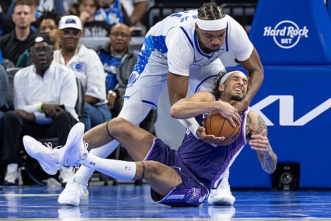 Sacramento Kings guard Devin Carter (22) fights to keep the ball from Orlando Magic center/forward Wendell Carter Jr. (34) during the second half of an NBA basketball game in Orlando, Fla.