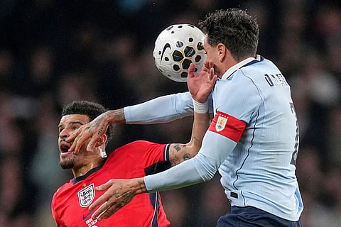 England's Dominic Solanke, left, and Uruguay's Jose Maria Gimenez battle for the ball during the international friendly soccer match between England and Uruguay in London.