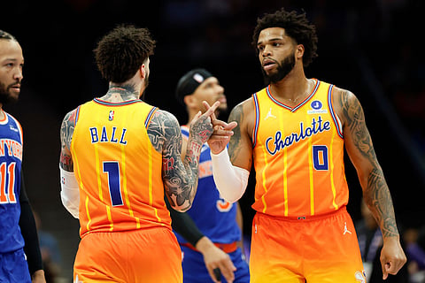 Charlotte Hornets forward Miles Bridges (0) celebrates with guard LaMelo Ball (1) after a basket against the New York Knicks during the first half of an NBA basketball game in Charlotte, N.C.